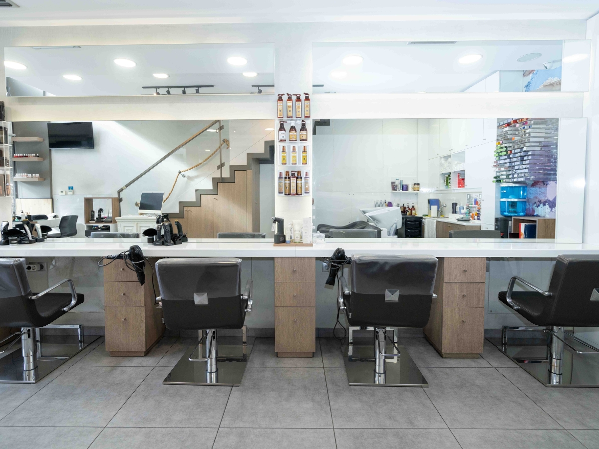 A professional salon interior showcasing a variety of hair styling stations